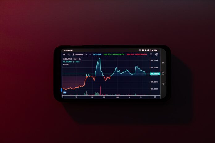 Photo by Jack B a cell phone displaying a stock chart on a red background