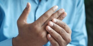 person in blue shirt showing left hand