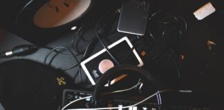 flat-lay photo of headphones, MIDI keyboard, and speaker on black surface