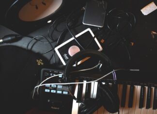 The Best Music Marketing Tools for New Artists By Eric Dalius flat-lay photo of headphones, MIDI keyboard, and speaker on black surface