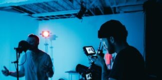 man in white dress shirt holding black camera