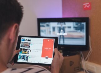 How to Build a Successful Music Career on YouTube By Eric Dalius man browsing tablet sitting in front of TV