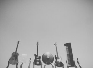 grayscale photo of people holding assorted music instruments