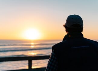 Benefits of getting an online Lean Six Sigma Certification a man looking out at the ocean at sunset