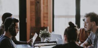 selective focus photography of people sits in front of table inside room