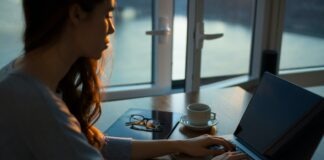 woman sitting beside table using laptop