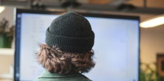 person in green shirt wearing black knit cap