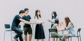 two men and four women meeting in office