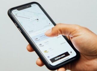 Which is Safer? Uber or Lyft a person holding a cell phone in their hand