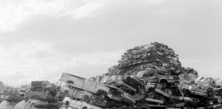 grayscale photo of wrecked cars on field