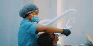 a woman getting her teeth brushed by a dentist