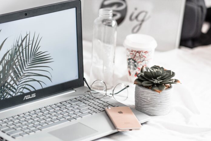 Photo by Aleksander Vlad turned-on Asus laptop near eyeglasses, succulent plant, and empty clear glass bottle