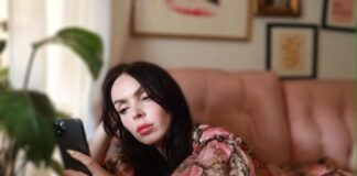 a woman laying on a couch looking at a cell phone