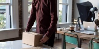 person holding cardboard box on table