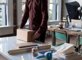 What is Dropshipping Business person holding cardboard box on table