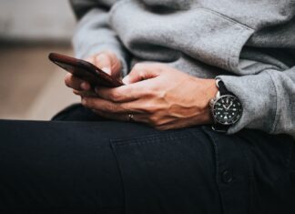 person in gray sweater wearing black and silver chronograph watch