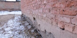 a brick wall that has been partially covered in snow