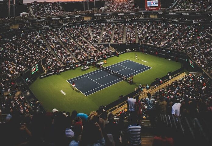 Photo by Filip Mroz people at the tennis court stadium during sunset