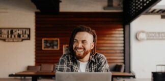 man in black and white plaid dress shirt using silver macbook