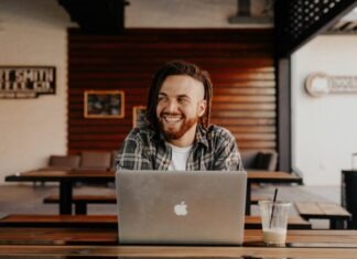 man in black and white plaid dress shirt using silver macbook