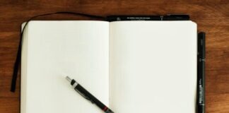 black and silver retractable pen on blank book