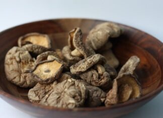 brown and black coffee beans in brown wooden bowl