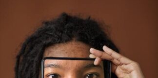 Free A Woman Holding a Smartphone with Eyes Picture on Screen Stock Photo