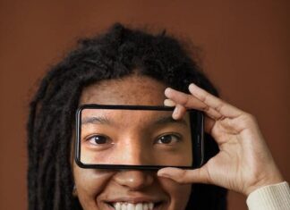 Best Apps for Improving Eye Health Free A Woman Holding a Smartphone with Eyes Picture on Screen Stock Photo