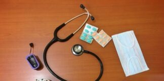 black and silver stethoscope on brown wooden table