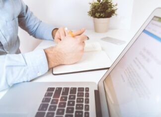 person writing on white notebook