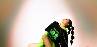 boy in black and green t-shirt and black pants sitting on floor