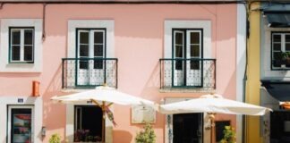 two white patio umbrellas near pink and white painted concrete building