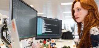 woman in green shirt sitting in front of computer