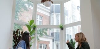 woman in black long sleeve shirt sitting beside woman in blue long sleeve shirt