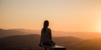 woman sitting on bench over viewing mountain