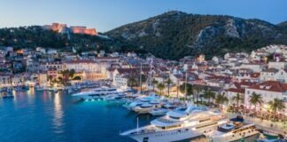 white ship on body of water near city buildings during daytime