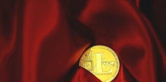 a close up of a gold coin on a red cloth