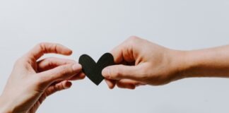 two person holding papercut heart