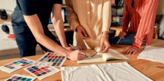 Cropped shot of designers drawing sketches, while creating logo and design of T-shirt. Young man and women working together at custom T-shirt, clothing printing company. Horizontal shot