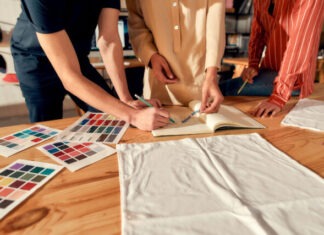 How To Effectively Market Your Brand Merchandise Cropped shot of designers drawing sketches, while creating logo and design of T-shirt. Young man and women working together at custom T-shirt, clothing printing company. Horizontal shot