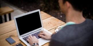 man in front of laptop computer in shallow focus photography