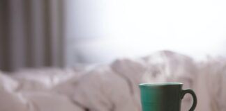 green ceramic mug on wooden desk