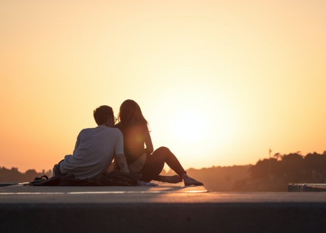 Photo by Khamkéo Vilaysing couple sitting near trees during golden hour