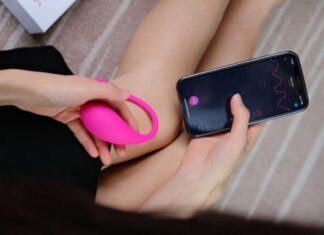 Pleasure Beyond Boundaries: Inclusive Sex Toys for Every Body and Identity a woman holding a cell phone and a pink object