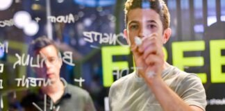 man writing on glass board