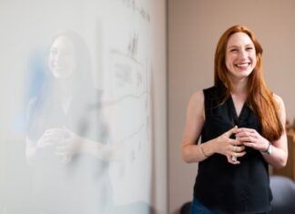 How to Become a Leader in Education Settings woman in blue tank top standing beside white wall