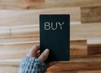 Artificial Intelligence Trading Bots: Automated Strategies for Cryptocurrency and Stock Markets a person holding a black book with the word buy written on it