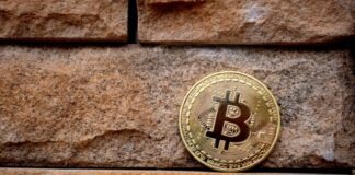 gold round coin on brown brick wall