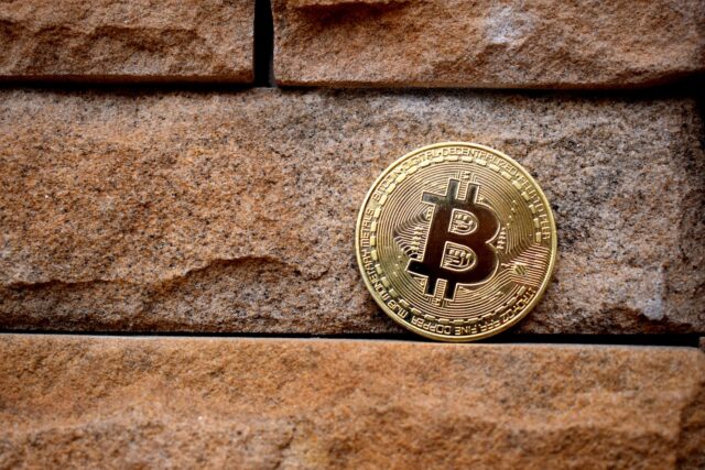 Photo by Kanchanara gold round coin on brown brick wall