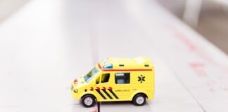 yellow car toy on white surface